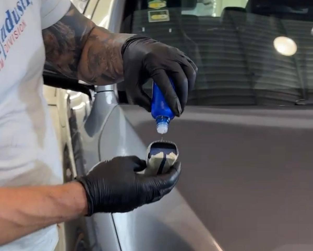 Técnico cargando el aplicador con recubrimiento cerámico en Detailing Factory, CDMX
