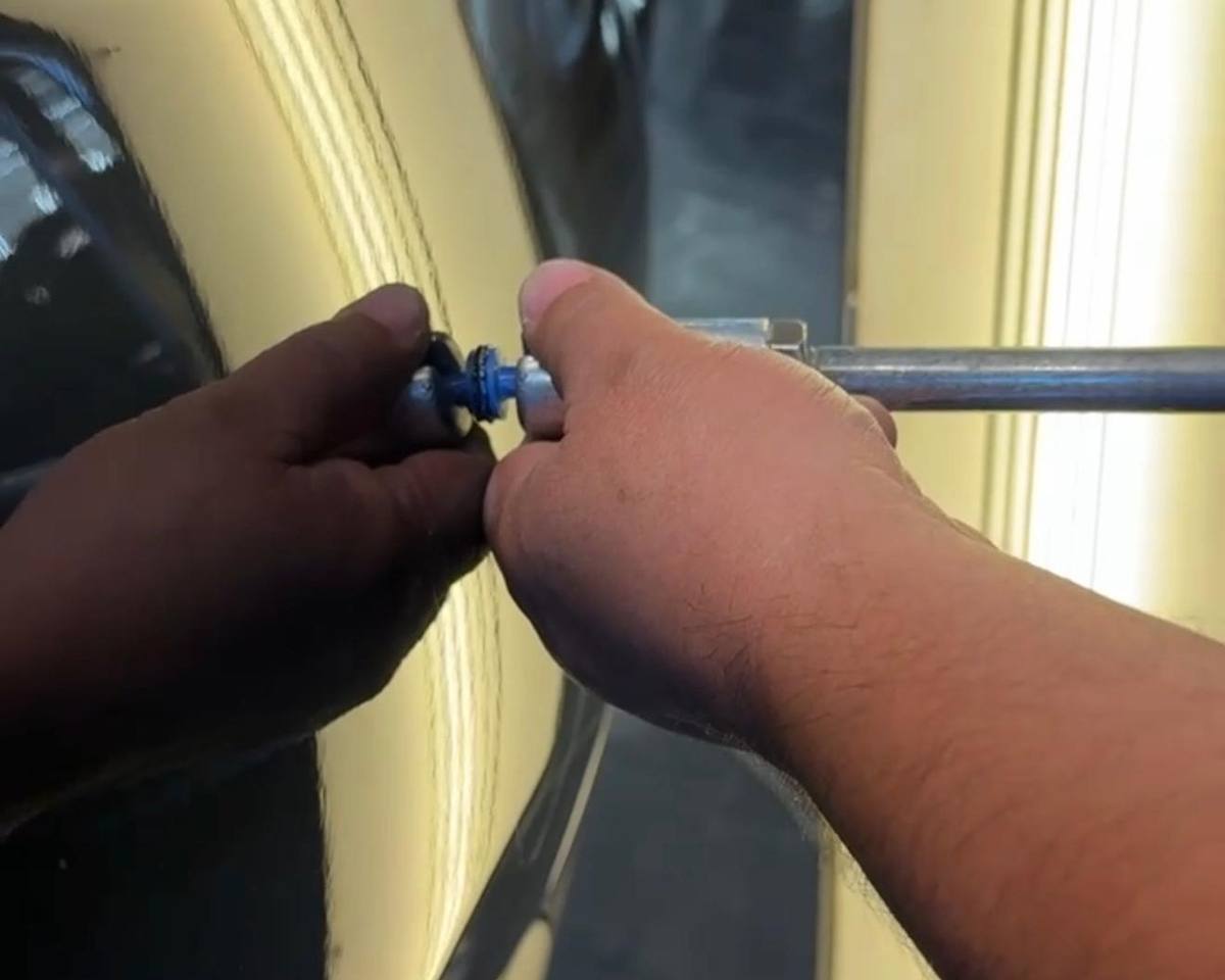 Extractor de PDR sacando un hundido frente a la lámpara de rayas en Detailing Factory, CDMX